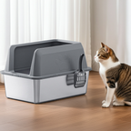 Cat standing next to a gray covered cat litter box on a wooden floor.