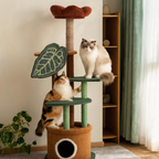 Two cats exploring a botanical cat tree with green platforms, a leaf-shaped scratching panel and a brown flower perch.