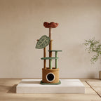 Botanical cat tree displayed on a white plinth, showing its flower perch, green platforms and plant-pot-style hideaway.
